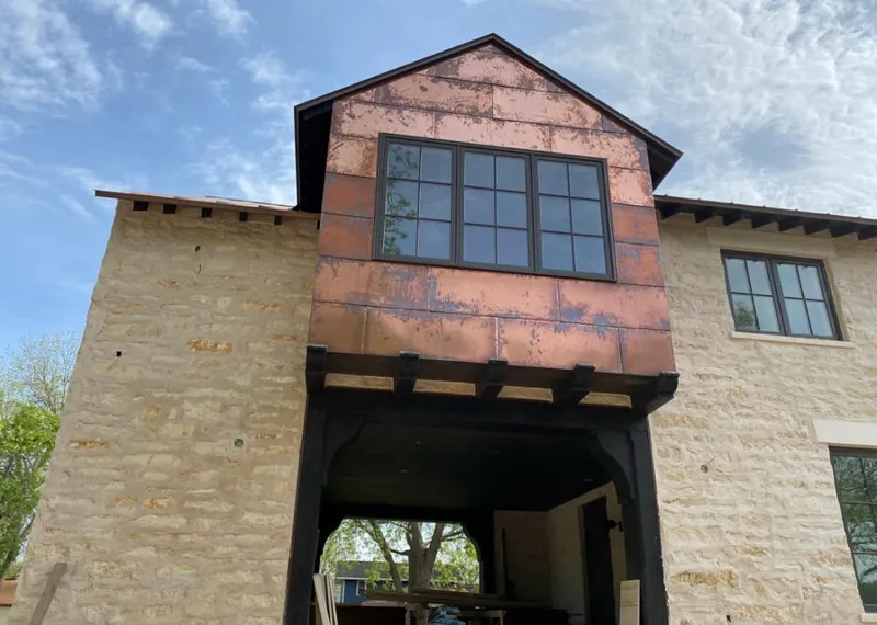 Copper metal panel facade on a stone building for Skylight Installation in Pebble Creek